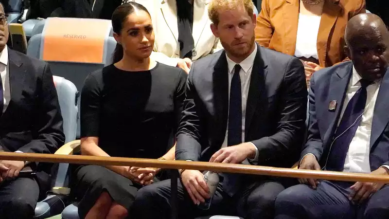 Meghan Markle is photographed handing a coughing woman a water bottle.