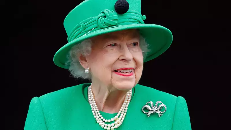 The Queen assists the Crown Princess of Greece in her wedding dress for a portrait shoot.