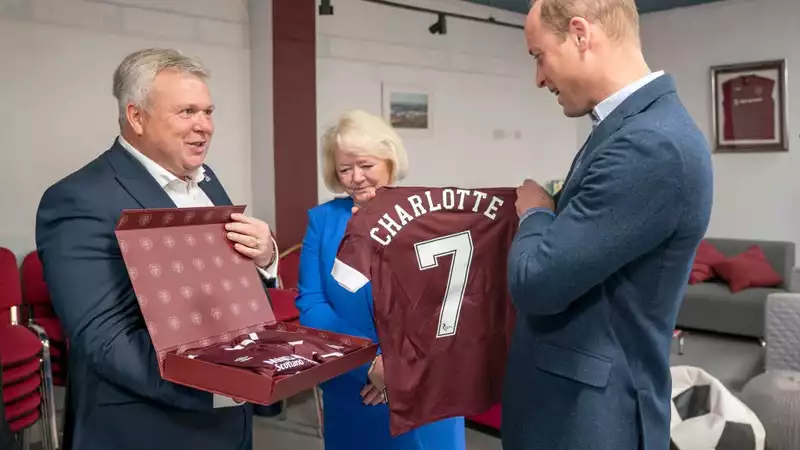 Princess Charlotte presents her parents with a soccer shirt on their visit to Scotland.