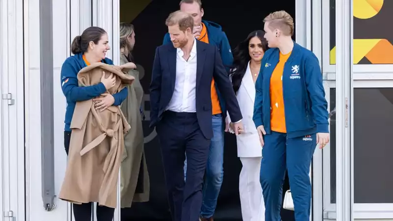 Meghan Markle hands over her coat to keep her newborn warm.