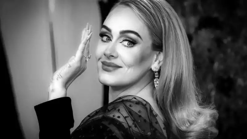 Adele wears a giant diamond on her ring finger as she accepts three BRIT Awards