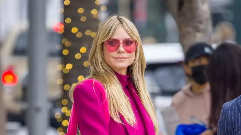 Heidi Klum presents the ultimate workwear for 2022 in a fuchsia pantsuit.