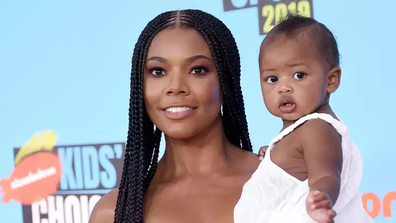 Gabrielle Union and her daughter Kaavia, twins in blue, dance in the pool.