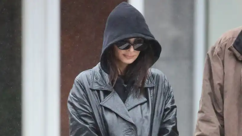 Emily Ratajkowksi demonstrates a trendy layering trick on a rainy day