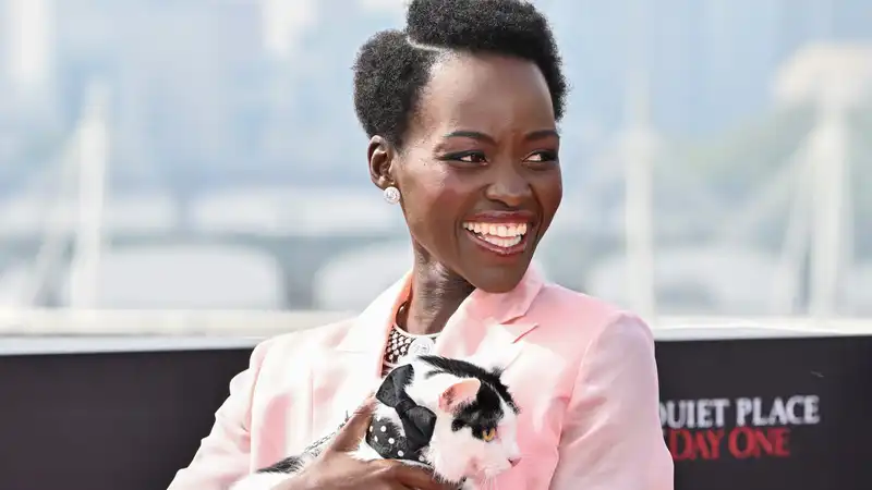 Why did Lupita Nyongo accessorize her bubblegum suit with a live cat?