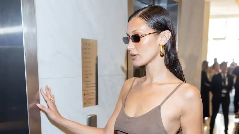 Bella Hadid kicks off her Cannes acquisition in a shiny brown mini dress