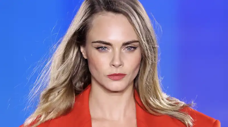 Cara Delevingne matches lipstick with a pantless (shirtless) outfit at Paris Fashion Week.