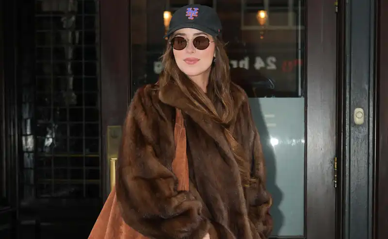 Dakota Johnson matches the suede bag trend with a fur jacket worthy of a mob wife.