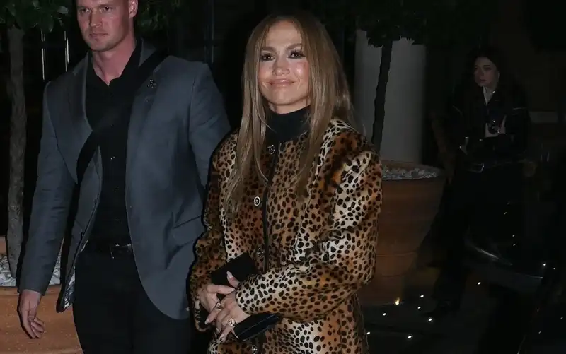 Jennifer Lopez doubles down on the leopard print trend with a coat dress and slouchy boots