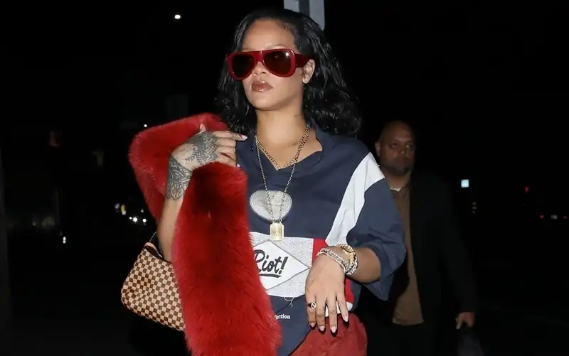 Rihanna wins the winter color trend hat trick with a red sheer skirt, sunglasses and a vintage fox fur stall