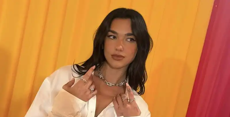 Dua Lipa offers a winter white master class with a button-down dress and aネ83,000 necklace