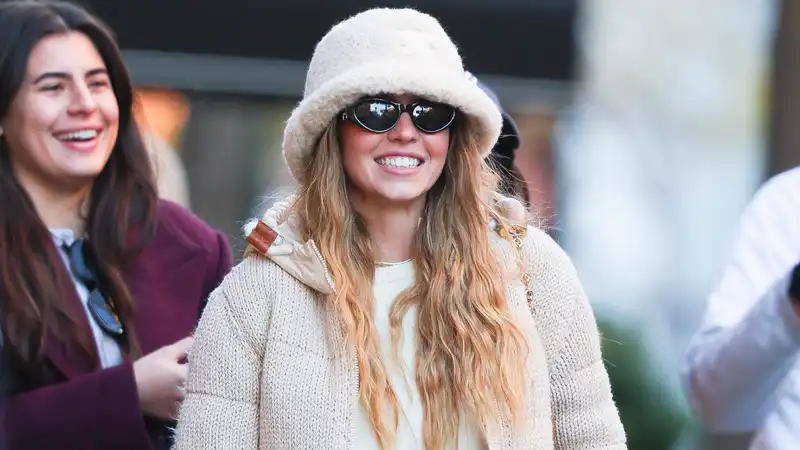 Sydney Sweeney, winter maximalism in fur bucket hat and cardigan knit puffs.